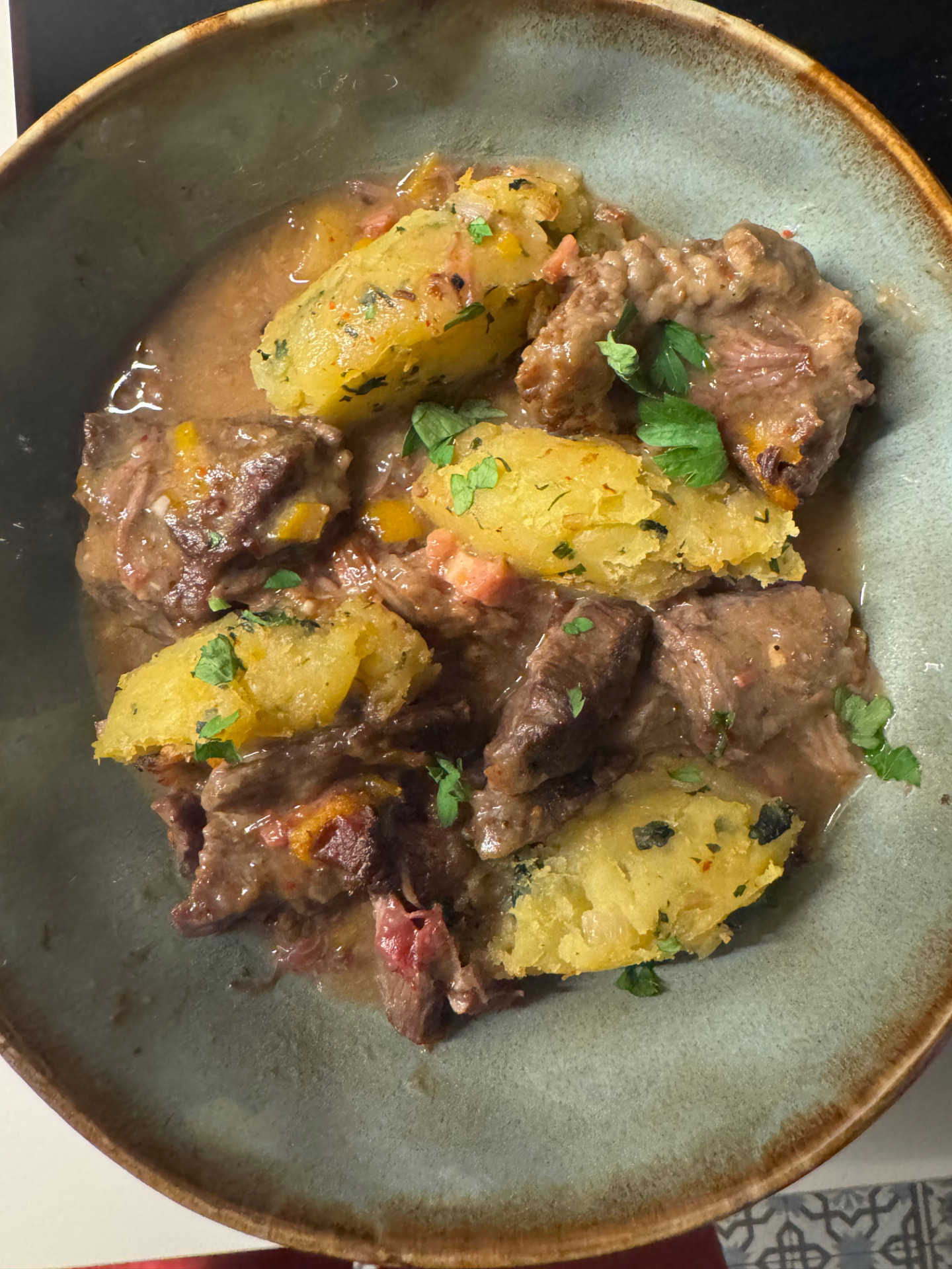 Un plat mijoté de la semaine, servi avec pommes de terre et herbes fraîches